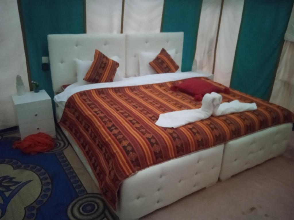 AdrouineMerzouga Chebbi camp的一间卧室配有一张带两条白色毛巾的床
