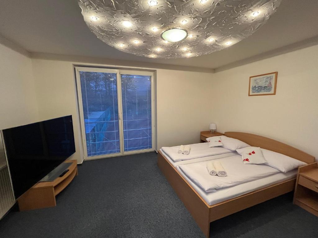 BrezanyRaketa Residence, hotel & restaurant的客房设有两张床、一台电视和一扇窗户。