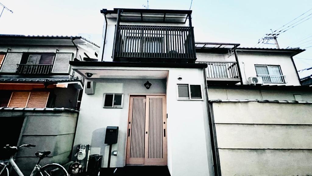 Nishinotōindōri花田屋HANADAYA的白色的建筑,有红色的门,上面有阳台