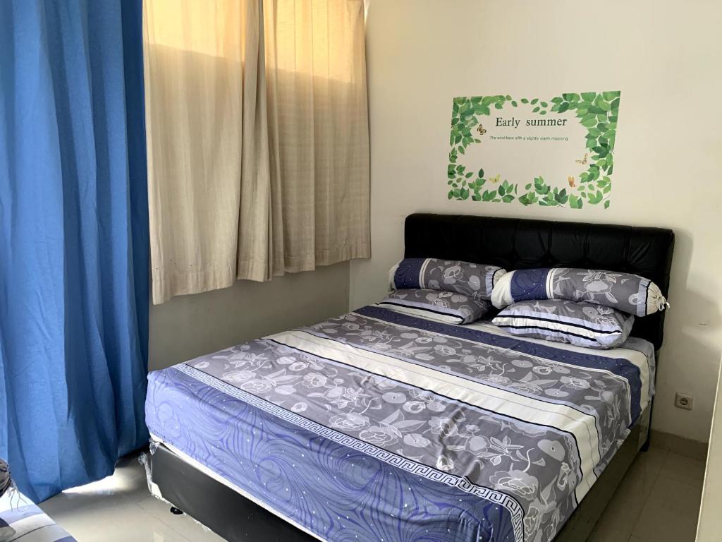 日惹Awana Dream 4 bedrooms house , 5min to Alun Alun, Kraton, Malioboro bdc的一间卧室配有一张带蓝色床单和枕头的床。