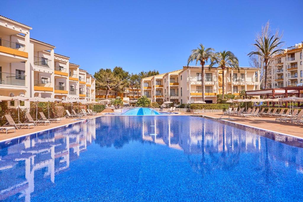 阿尔库迪亚港扎菲罗热带公寓的棕榈树和建筑度假村的游泳池