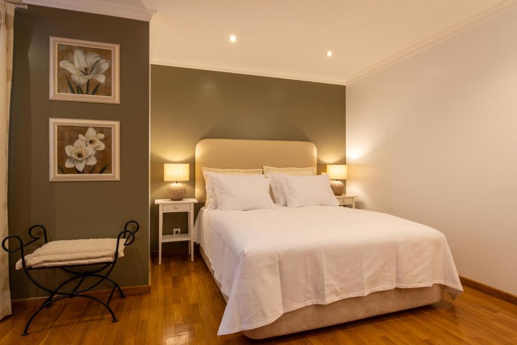 法鲁Miradouro da Penha的卧室配有一张白色大床和两盏灯。