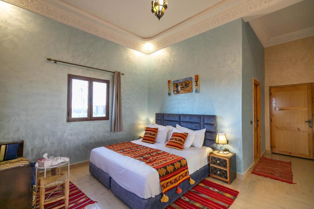 梅尔祖卡Berber Palace Merzouga的一间卧室设有一张大床和一个窗户。