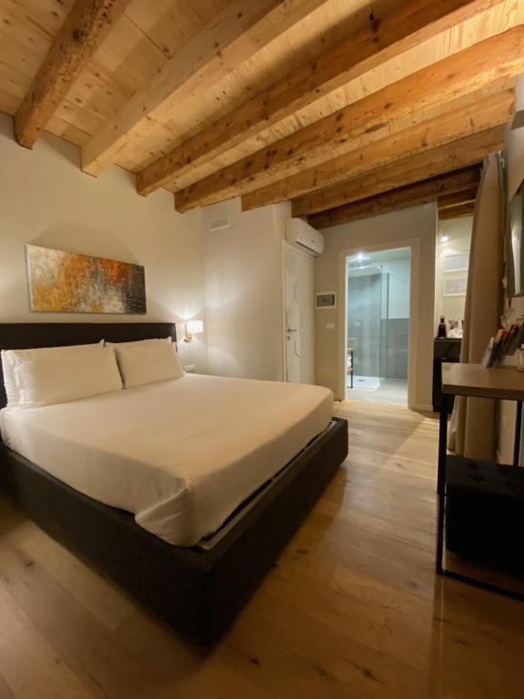 代森扎诺-德尔加达Malvezzi24 Boutique Rooms的一间卧室设有一张大床和木制天花板。