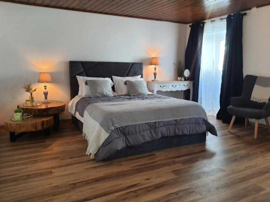 拉戈阿Stone House的一间卧室设有一张大床,铺有木地板