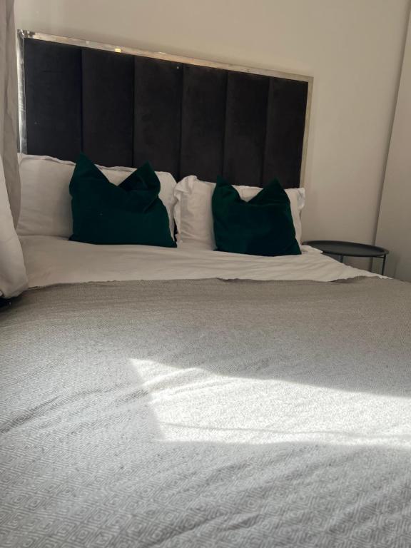 博勒姆伍德Borehamwood stay的床上有两张绿色枕头