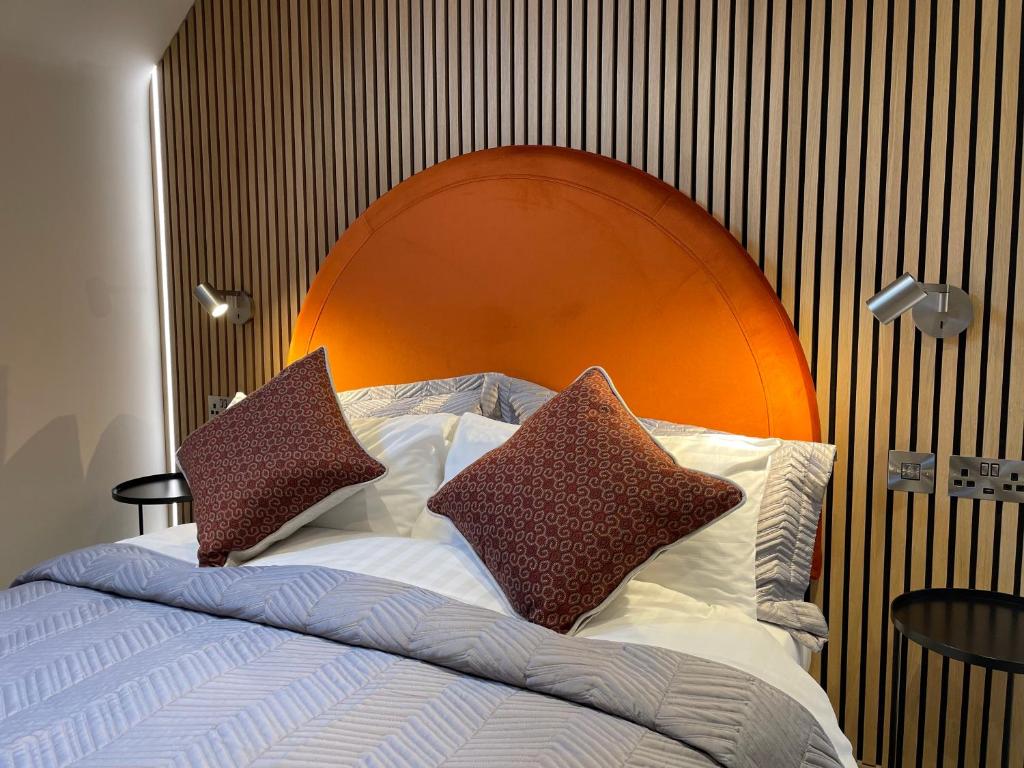 法灵登The Boutique Hotel的一张带橙色床头板和枕头的床