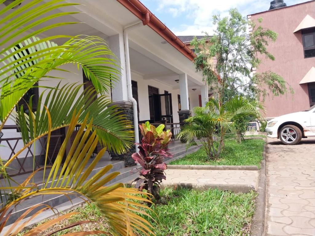 坎帕拉Travel Sanctuary Residence - Uganda的前面有棕榈树的房子