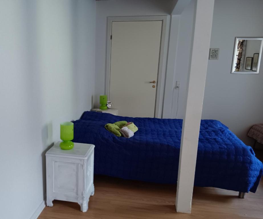 GørdingBøelgaarden的一间卧室配有一张蓝色的床和一张桌子
