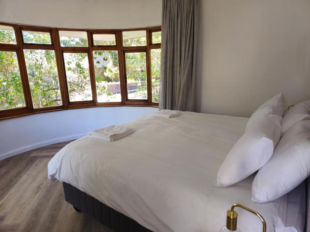 开普敦WunderLux的带窗户的客房内的白色床和枕头