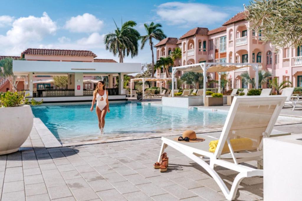棕榈滩加勒比棕榈度假酒店的一位妇女走进度假村的游泳池