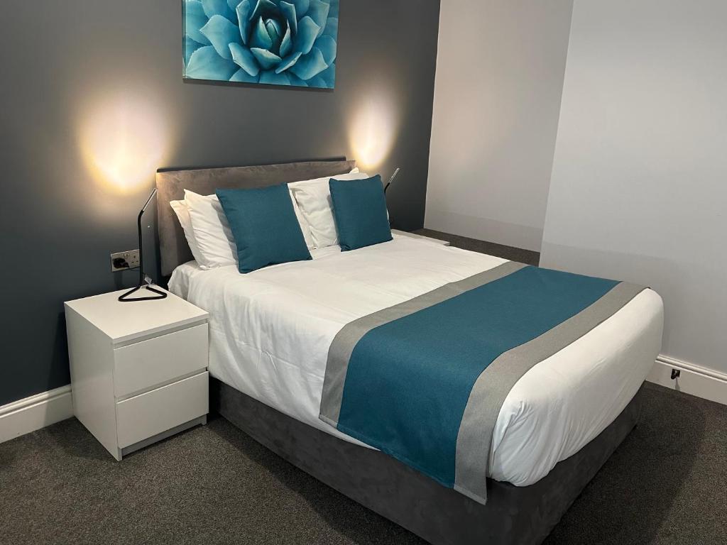 贝辛斯托克Arlan House, Central Basingstoke Hotel的一间卧室配有蓝色和白色的床