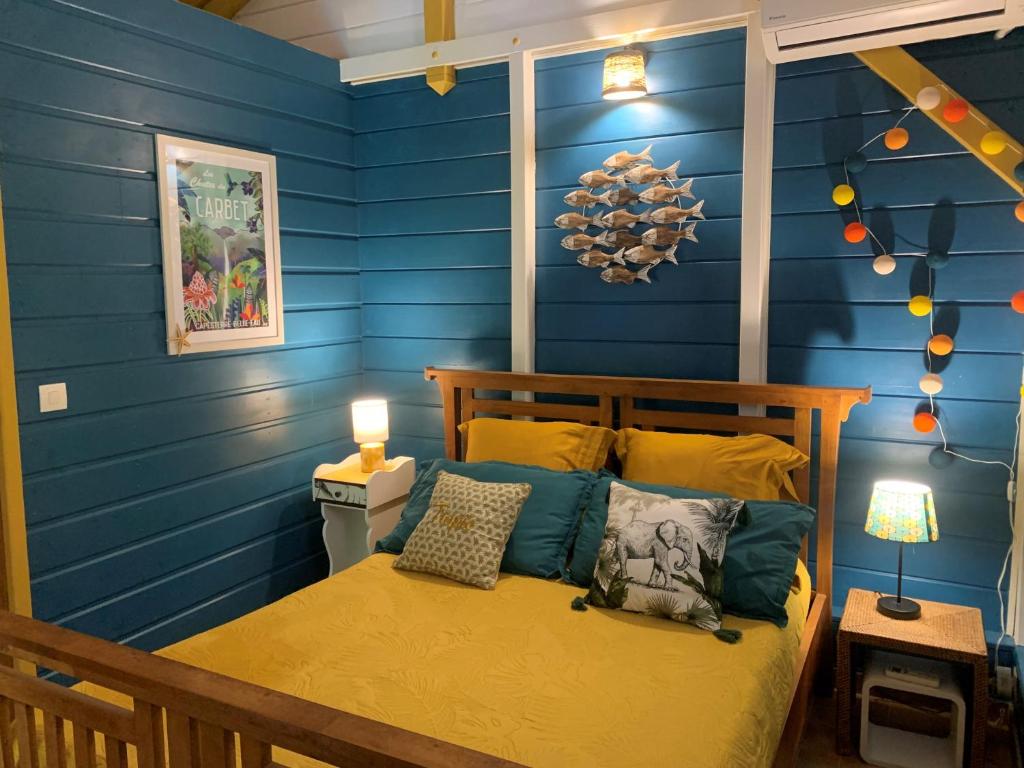 圣弗朗索瓦Un p'tit coin Zen的一间卧室拥有蓝色的墙壁,配有一张带枕头的床。