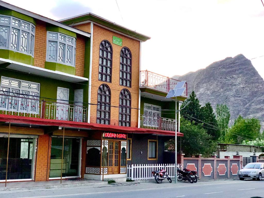 锡卡都Skardu Lodge的停在前面的一座带摩托车的建筑