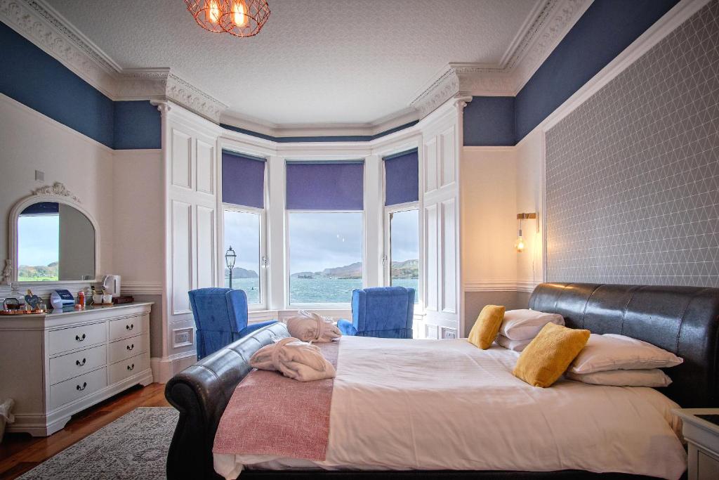 奥本马凯斯旅馆的一间卧室设有一张大床,拥有蓝色的墙壁和窗户。