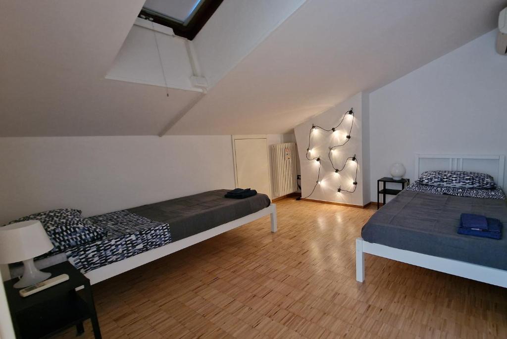维罗纳la casa della luce的一间卧室设有两张床,墙上配有一盏灯。