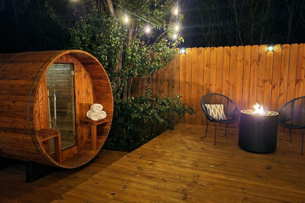 韦科5th St Getaway w Sauna Hot tub Firepit & Game Room的木甲板上设有木桶、椅子和木栅栏