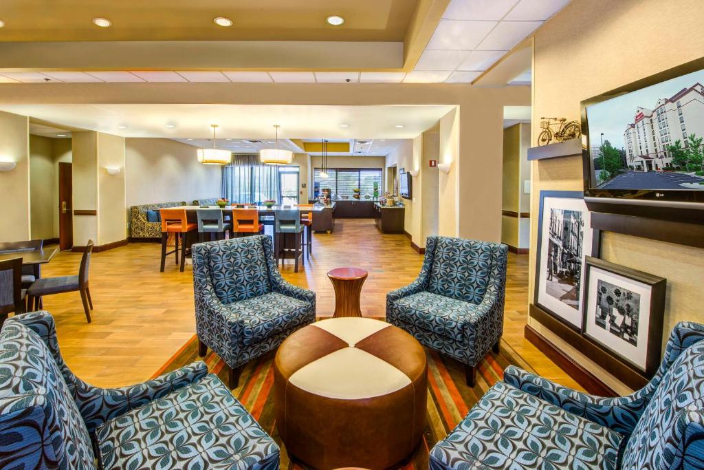 亚特兰大汉普顿酒店加亚特兰大广场套房的医院的大厅,有椅子和桌子