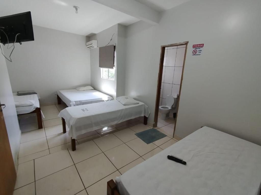 戈亚尼亚Hotel Oliveira 44的一间医院间,配有两张床和镜子