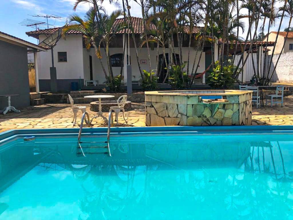 伊塔年杜Casa de campo com piscina, mesa de bilhar e 3 quartos的房屋前的游泳池
