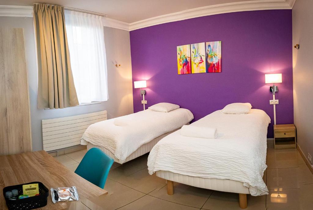 新城圣乔治Résidence Hélios Paris Orly Aéroport的一间设有两张床和紫色墙壁的客房