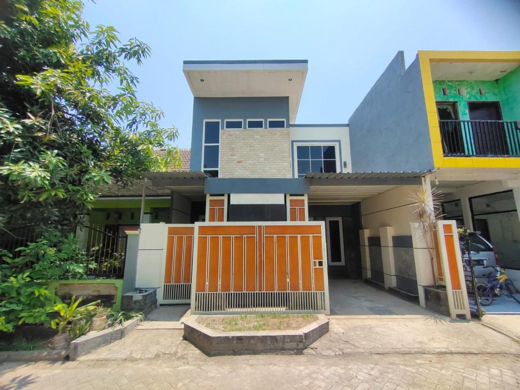 Mulia Homestay Pasuruan的前面有一个橙色门的房子