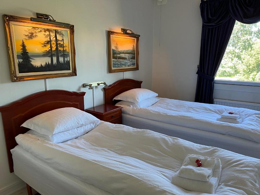 哥德堡波斯马特公寓的在酒店房间里放两张床,上面放着一只动物