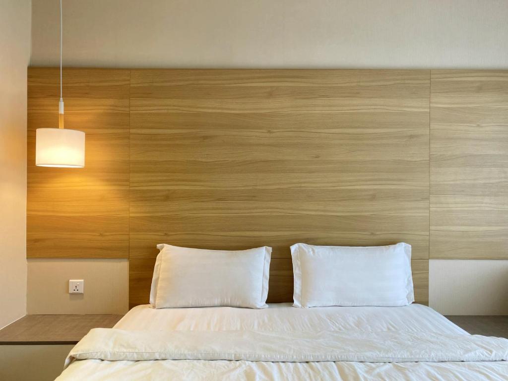 哥打京那巴鲁Aeropod Cactus Rail Suite With Balcony - Kota Kinabalu的一间卧室配有一张大床和木制床头板