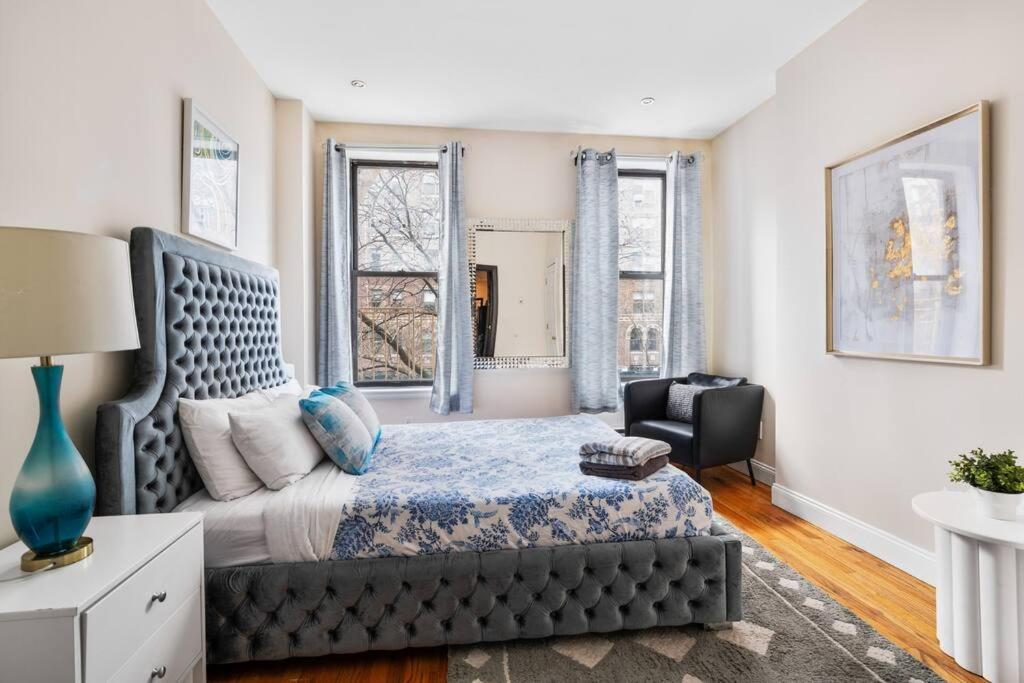 纽约Perfect Chic Apartment in Upper West of NYC!的一间卧室配有一张床、一把椅子和窗户。