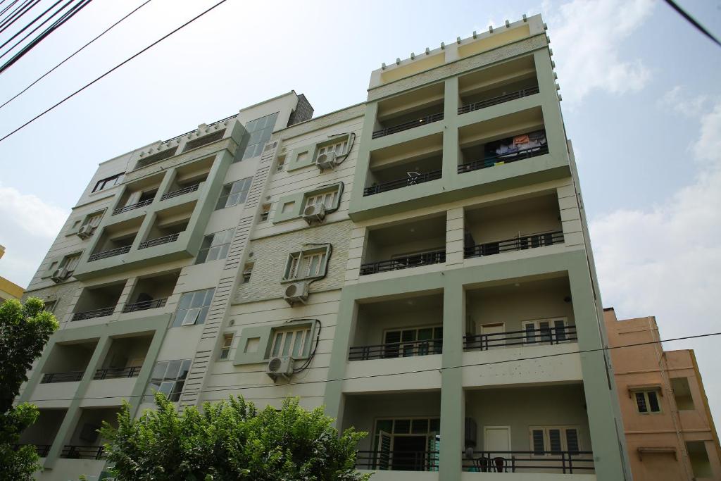 海得拉巴White Fern Stays Serviced Apartments - Gachibowli的带阳台的高高的白色建筑