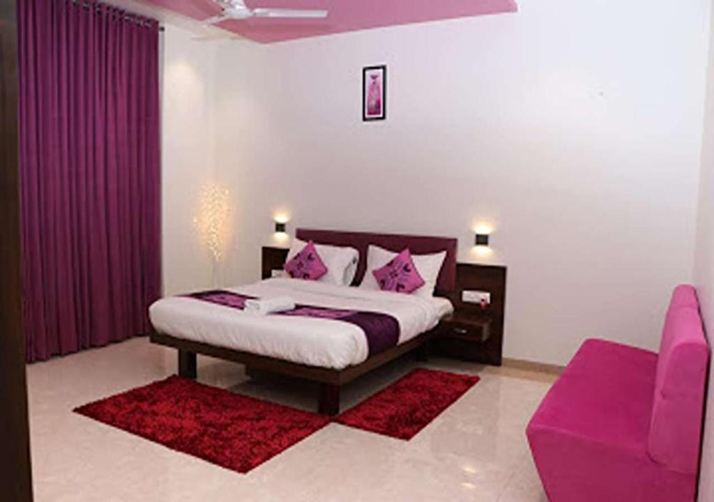 楠代德HOTEL CVR的一间卧室配有一张带粉色枕头的床和一张紫色沙发
