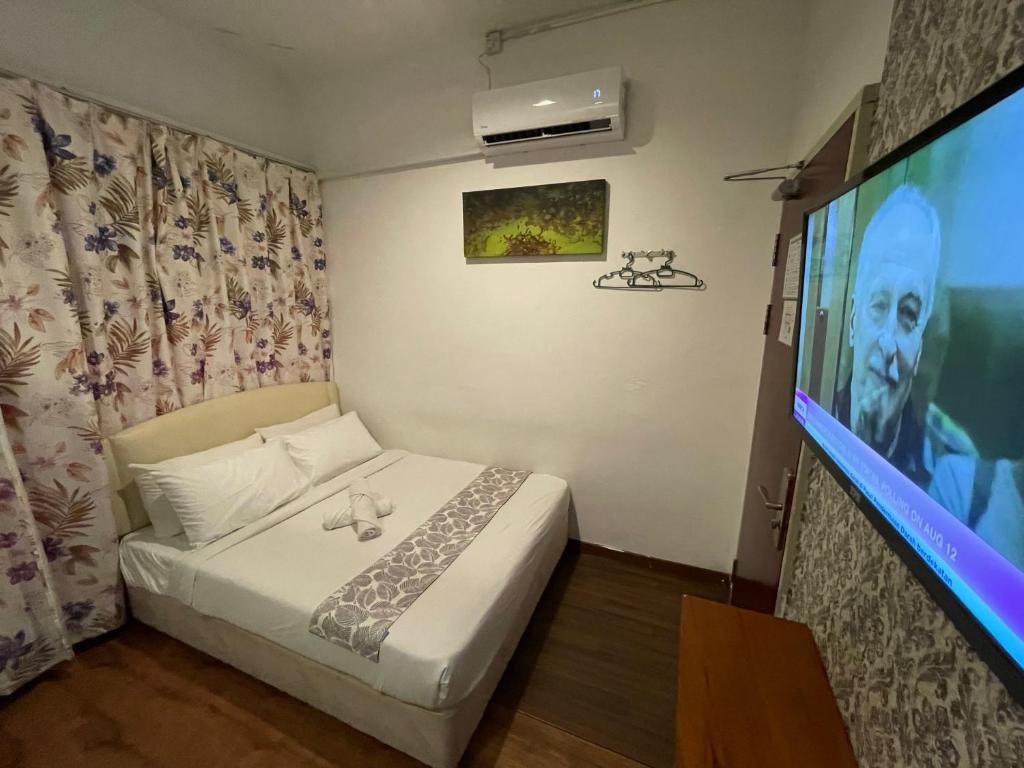 古晋古晋啄木鸟小屋的一间卧室配有一张床和一台平面电视
