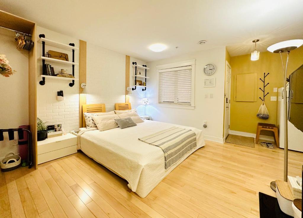 温哥华Private Guest Suite in Little Italy - King Bed - Free Parking - Central Location的一间卧室配有一张床和一盏灯