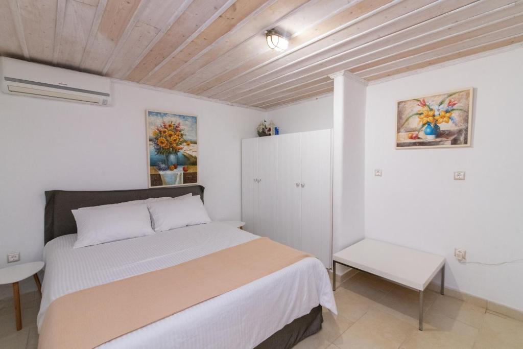 帕诺尔莫斯Panormos Art Villas & Suites的一间白色客房内的床铺卧室