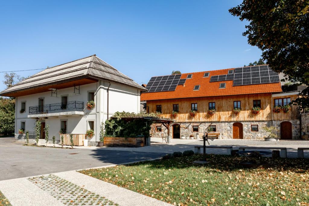Stari Trg pri LožuYouth Hostel Arsviva的屋顶上设有太阳能电池板的大型建筑