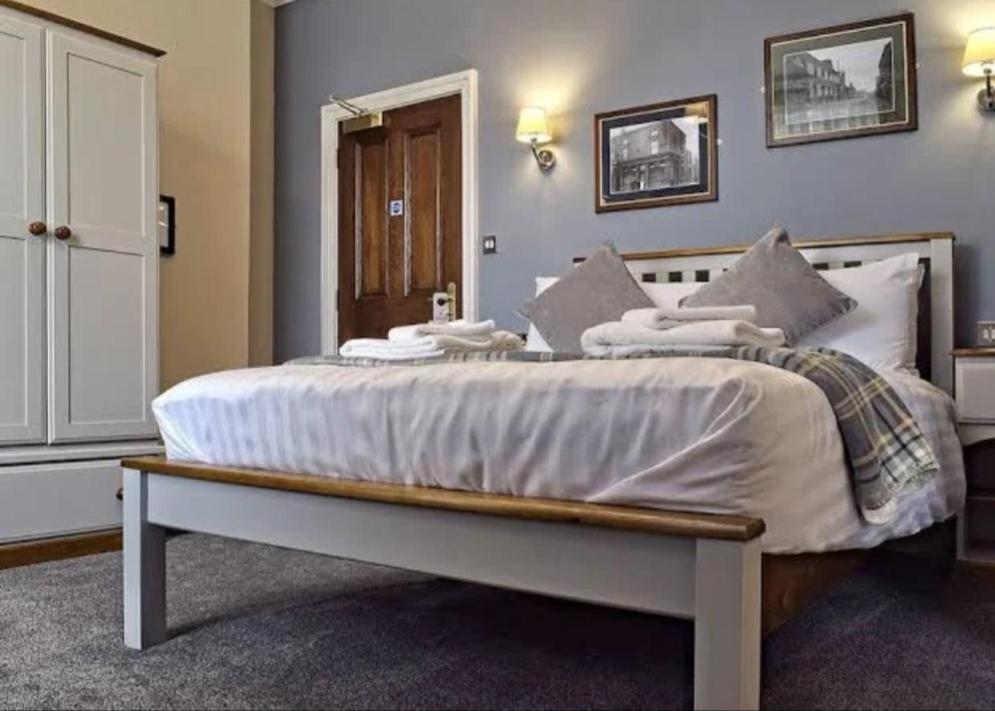 斯托桥The Seven Stars的卧室配有一张带白色床单和枕头的大床。