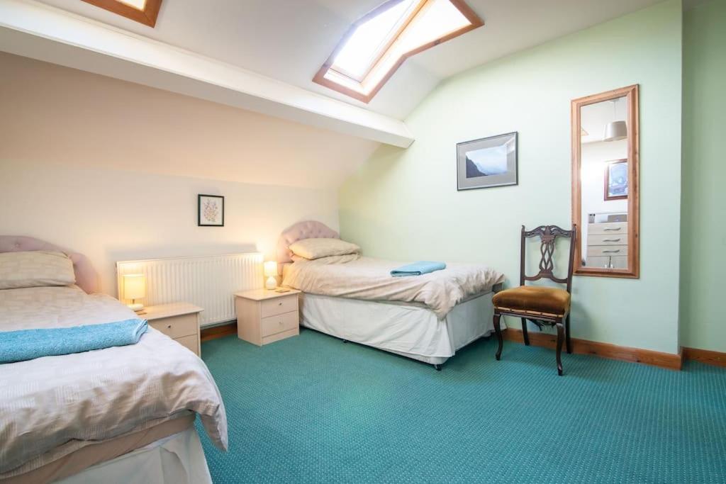 达尔文Midsummer Barn的一间卧室配有两张床、镜子和椅子