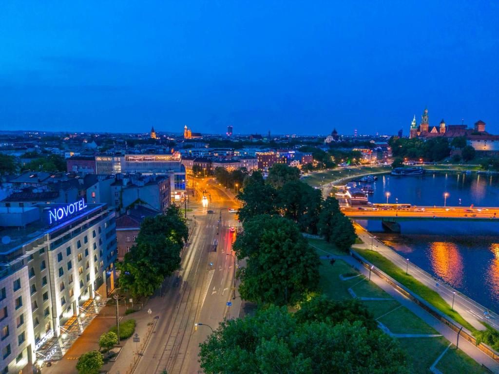 克拉科夫克拉科夫诺富特酒店的城市天际线,夜晚有河流和建筑
