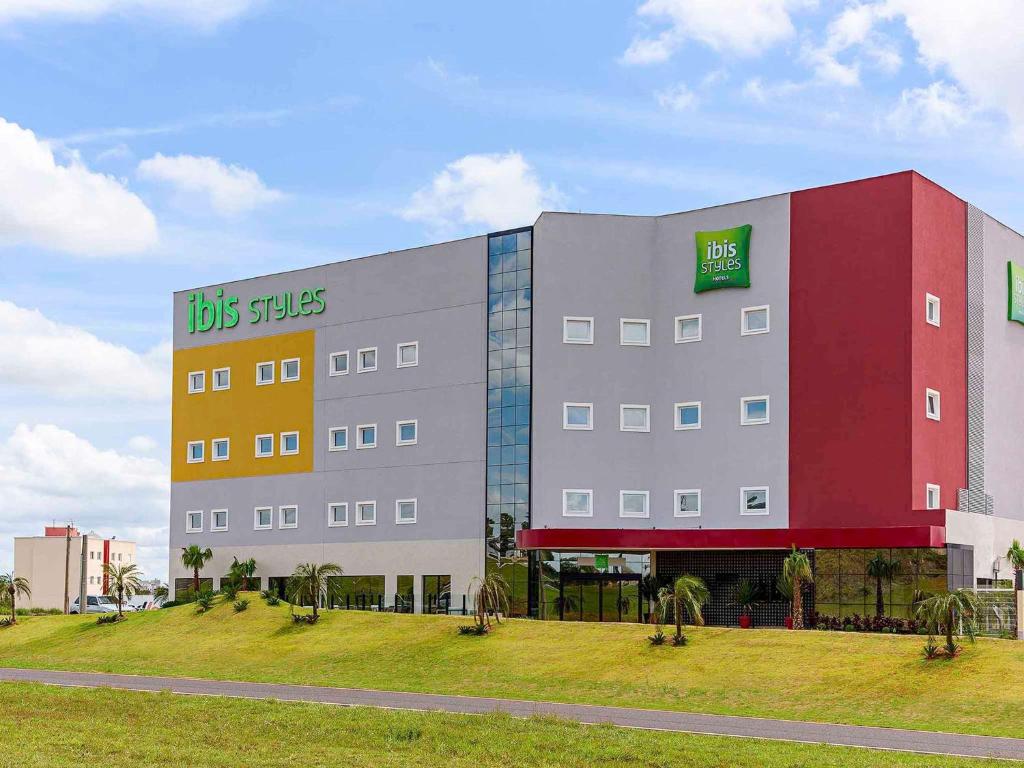 比里吉ibis Styles Birigui的一座大建筑的侧面有标志