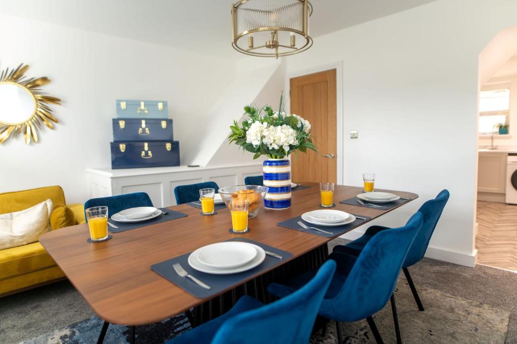 福克斯通Harbour Heights的一张带蓝色椅子和花瓶的餐桌