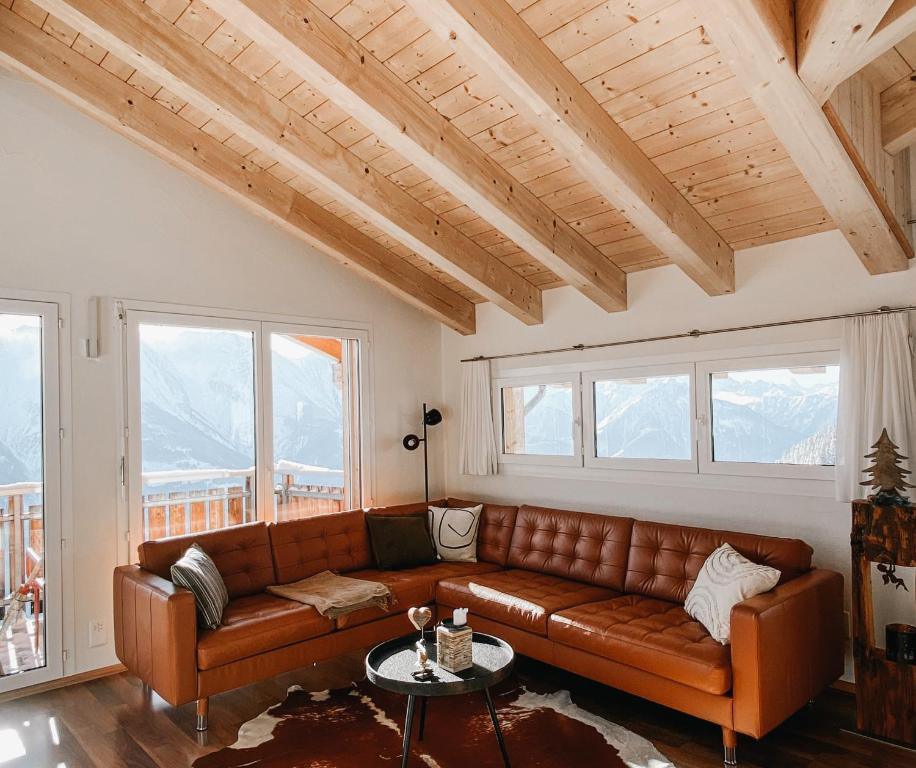 贝特默阿尔卑Bergquelle Dachwohnung的客厅设有棕色皮革沙发和窗户。