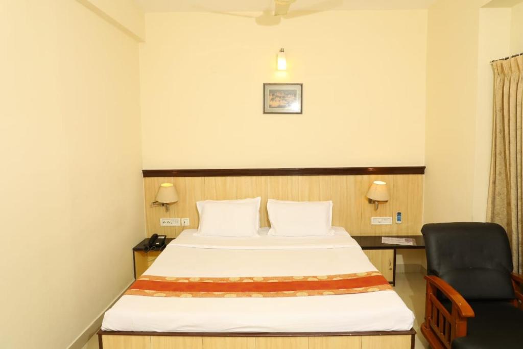 塞勒姆Hotel Shrie Shaanth的配有一张床和一把椅子的酒店客房