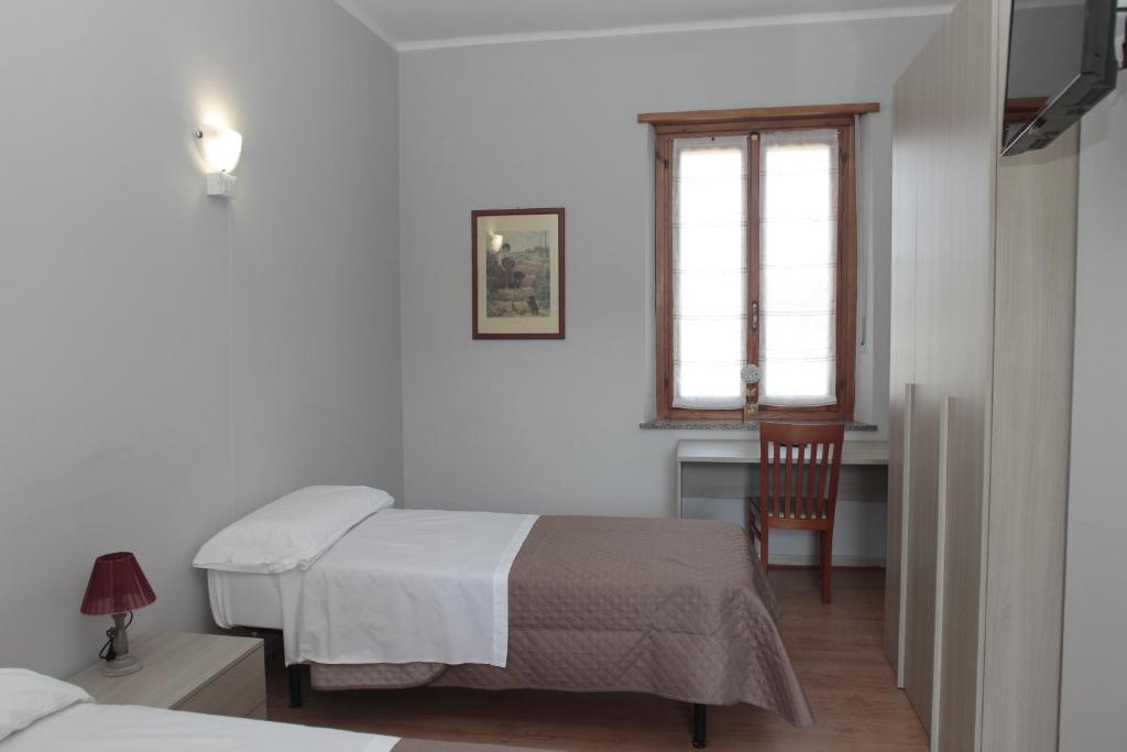 卡塞勒托瑞尼斯La Porta del Sole的一间卧室设有两张床、一张桌子和一个窗口。