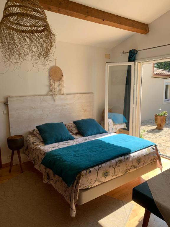 尼姆La chambre haute et son spa的一间卧室配有一张带蓝色枕头的床