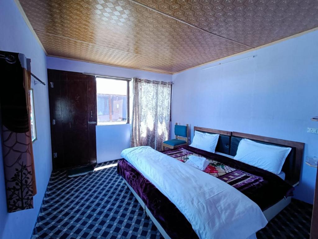 MerukNative Retreat Cottage , Pangong ladakh UT的一间蓝色客房内配有一张大床的卧室