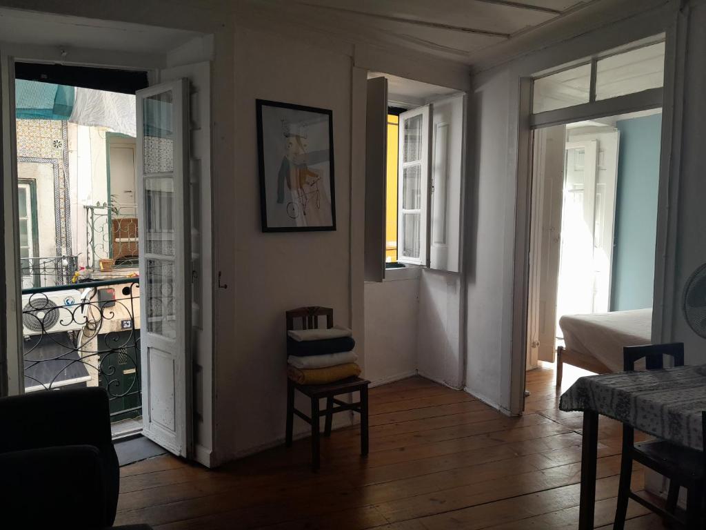里斯本Chiado / Carmo Small Artist Lodge的客厅配有椅子,门通往阳台