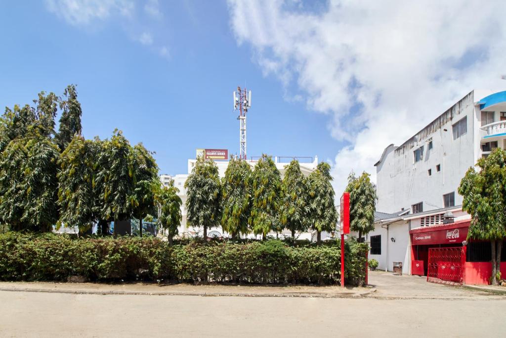 蒙巴萨Mombasa Railway Gardens Hotel的一条在大楼前有红杆的街道