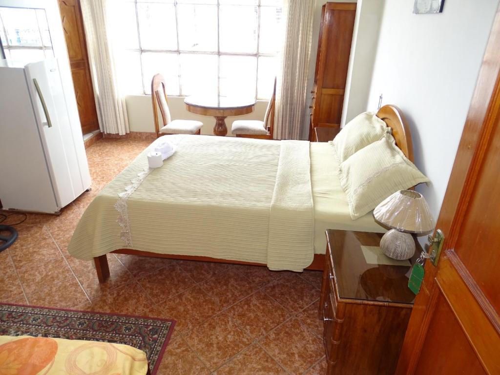 廷戈玛丽亚HOSTAL RESIDENCIAL UCAYALI的一间卧室配有一张床、一张桌子和一个窗户。