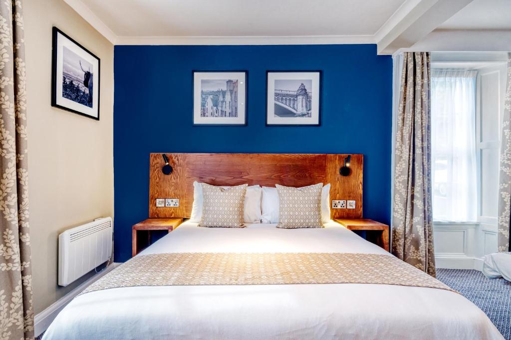 胡克The White Hart by Innkeeper's Collection的蓝色卧室设有一张带蓝色墙壁的大床