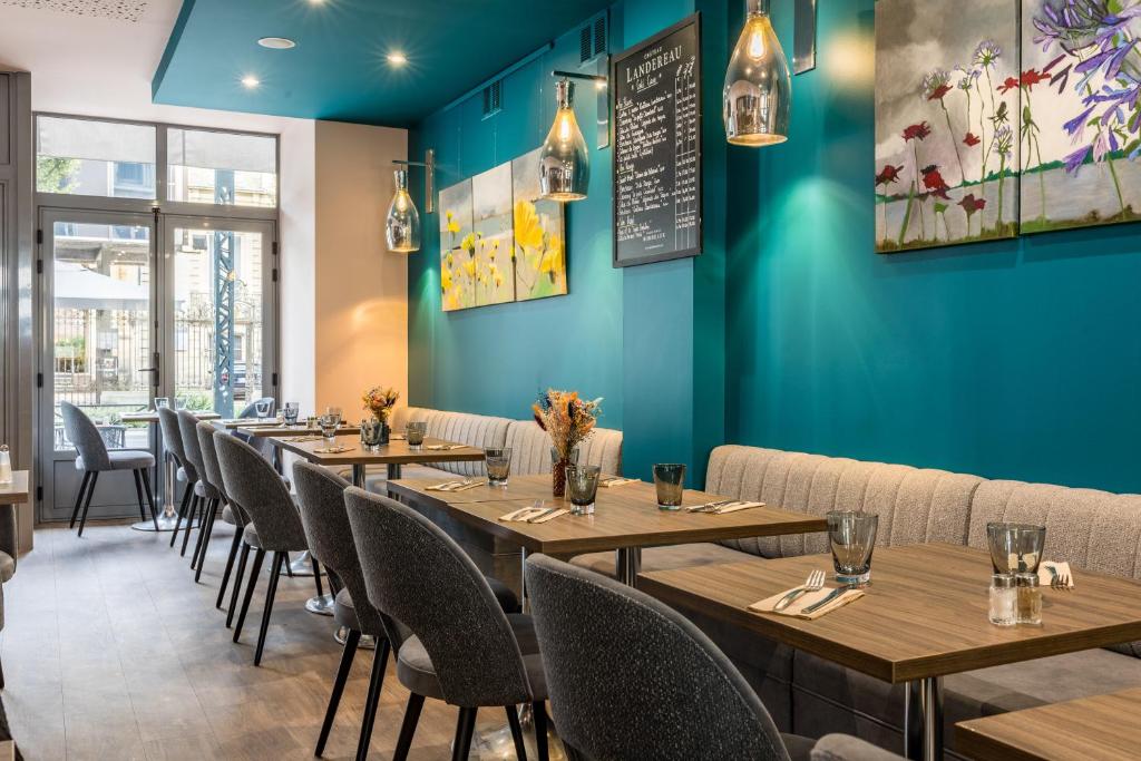 雷恩乐维多利亚餐厅酒店的蓝色墙壁的餐厅里的一排桌子
